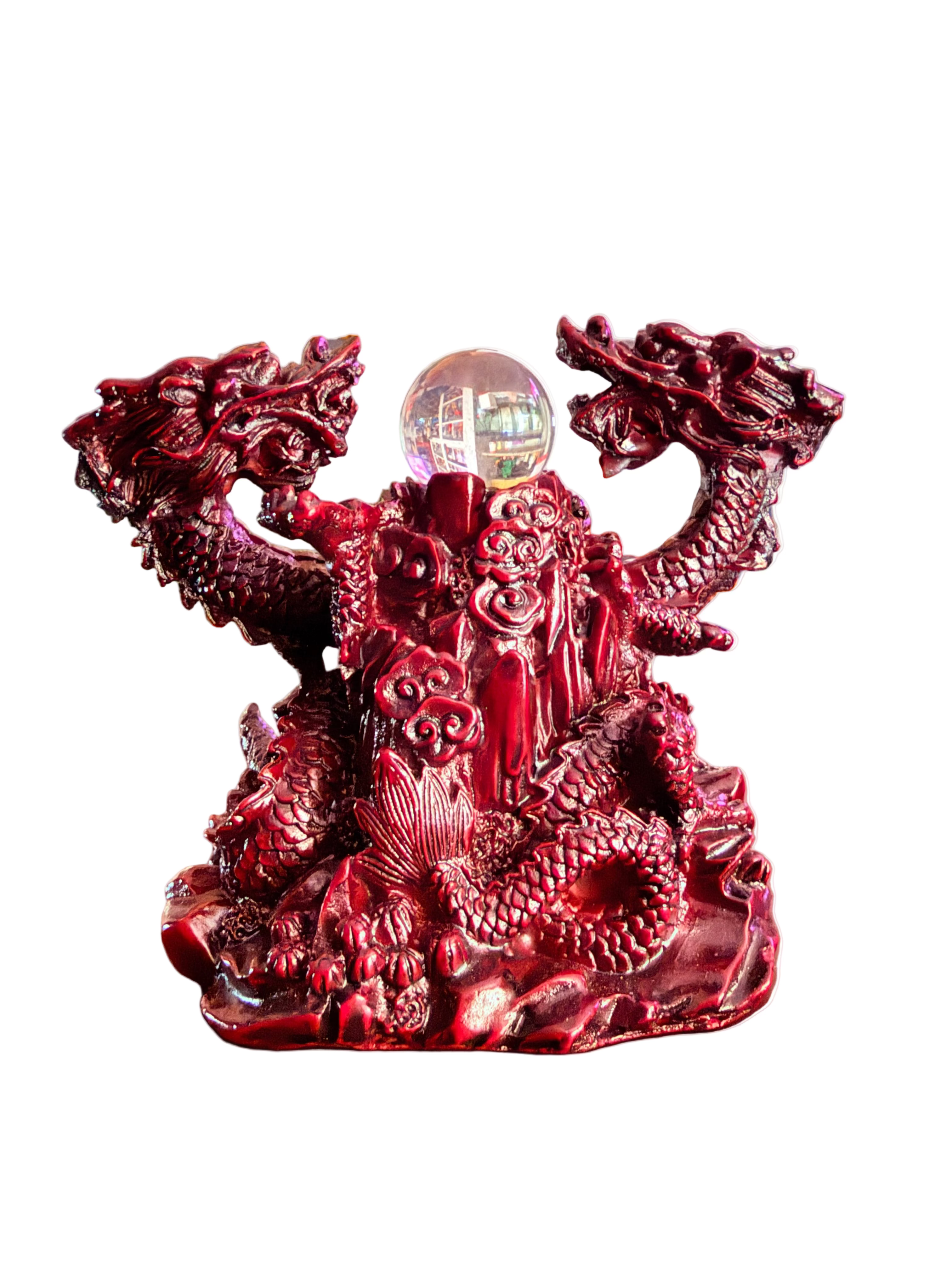 Decorative red dragon sculpture with a crystal ball on a table